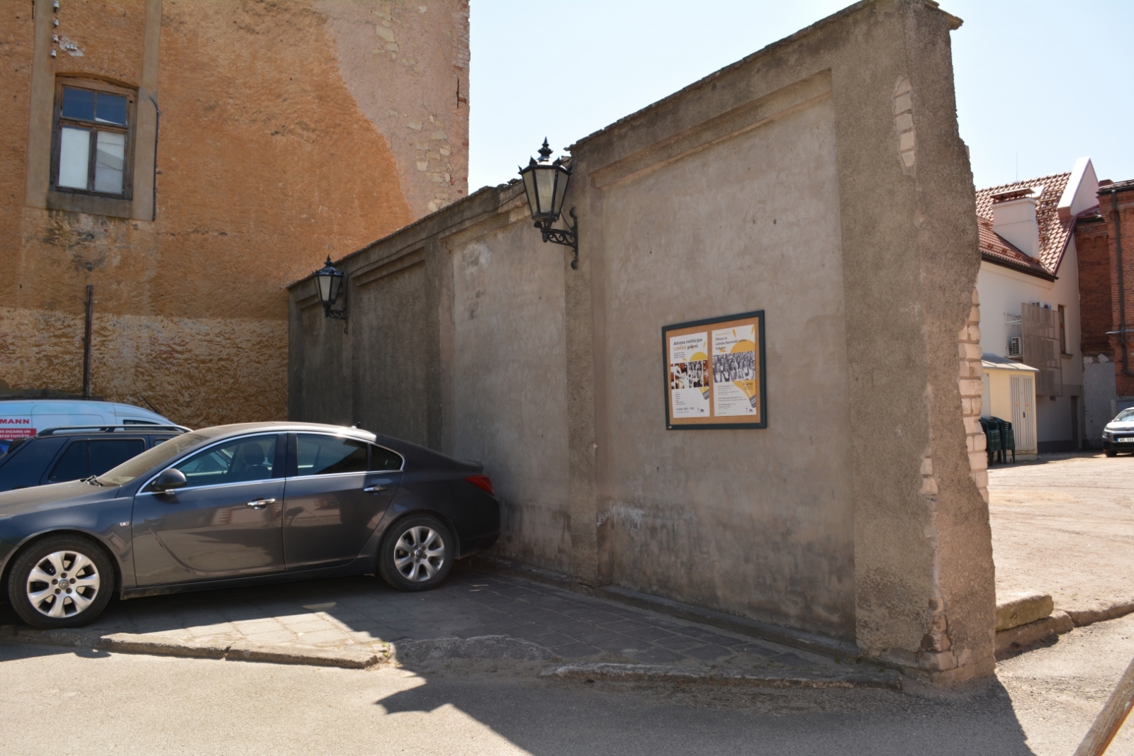 Krāsaina bilde, Cēsu ZVA mūra sēta ar afišu un vienu mašīnu