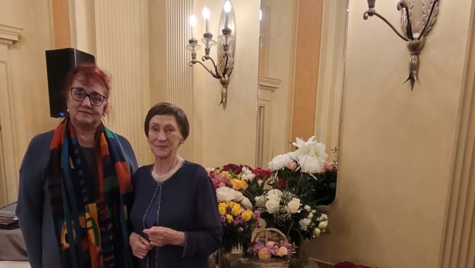 Krāsaina bilde, LNA arhīva eksperte Meldra Usenko sveic rakstnieci Māru Svīri 90 gadu jubilejāe un arhīva eksperte 