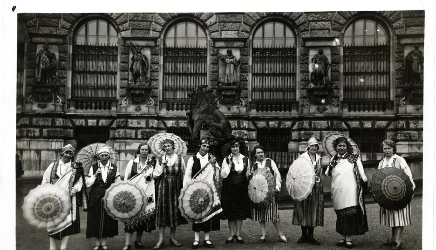 Grupas foto. Latviešu sieviešu nacionālā līgas dalībnieces ar lietussargiem