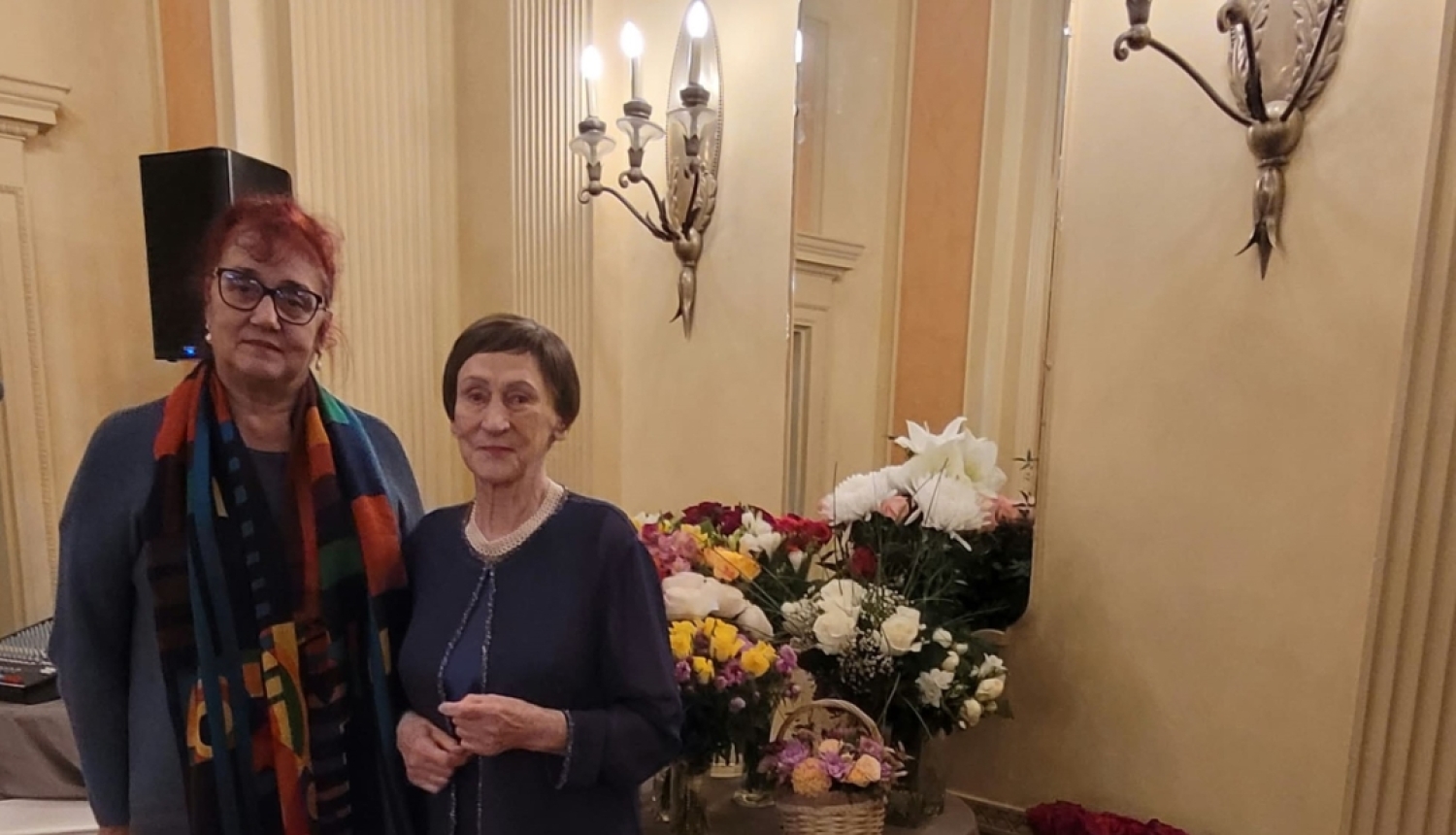 Krāsaina bilde, LNA arhīva eksperte Meldra Usenko sveic rakstnieci Māru Svīri 90 gadu jubilejāe un arhīva eksperte 
