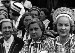Melnbalta bilde no izstādes "Dziesmas spēks", dziesmu svētku dalībnieces tautas tērpos, priekšplānā dziedātājas Bārtas novada tērpos