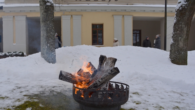 Krāsaina bilde, Balvu muzeja ēka fonā, priekšplāna degošs uzgunskurs