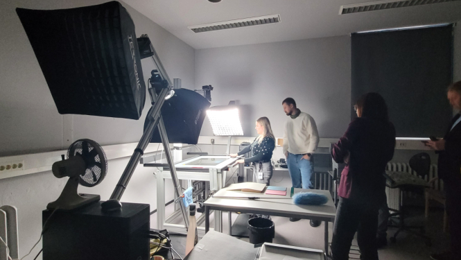 Krāsaina bilde, digitalizācijas galds ar lampām un darbiniekiem