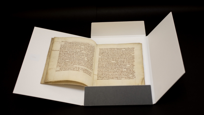 Krāsaina bilde, dokumentu mapē ievietots atvērts 13.gadsimta dokuments, tā nosaukums - Nogorodas kantora noteikumi jeb šrāgas 1295. gada redakcijā