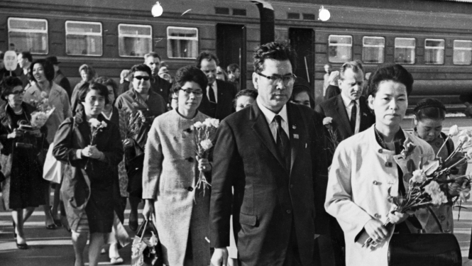 Japānas un Latvijas iedzīvotāju ar ziediem uz vilciena fona Rīgas dzelzceļa stacijā