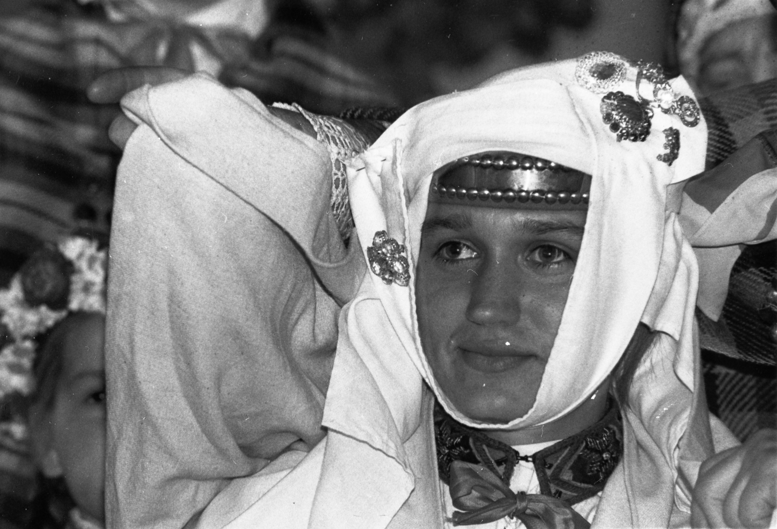 Melnbalta bilde no izstādes "Dziesmas spēks", svētku dalībnieces portrets, sievas galvas rota - galvauts, sasprausta ar saktām