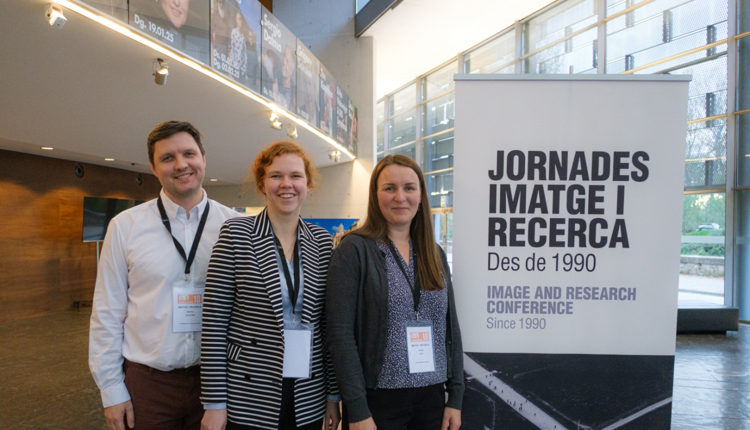 Krāsaina bilde, Latvijas Valsts kinofotofonodokumentu arhīva eksperts elektronisko dokumentu jautājumos Mārtiņš Krastiņš, Dokumentu izmantošanas nodaļas arhīva eksperte dokumentu izmantošanā Viktorija Gardoviča un arhīva eksperte aprakstīšanā Natālija Lāce 18. Starptautiskās konferences “Image & Research”norises vietā. Žirona, 2024. gada 22. novembrī, autors Aksela Van Meile.