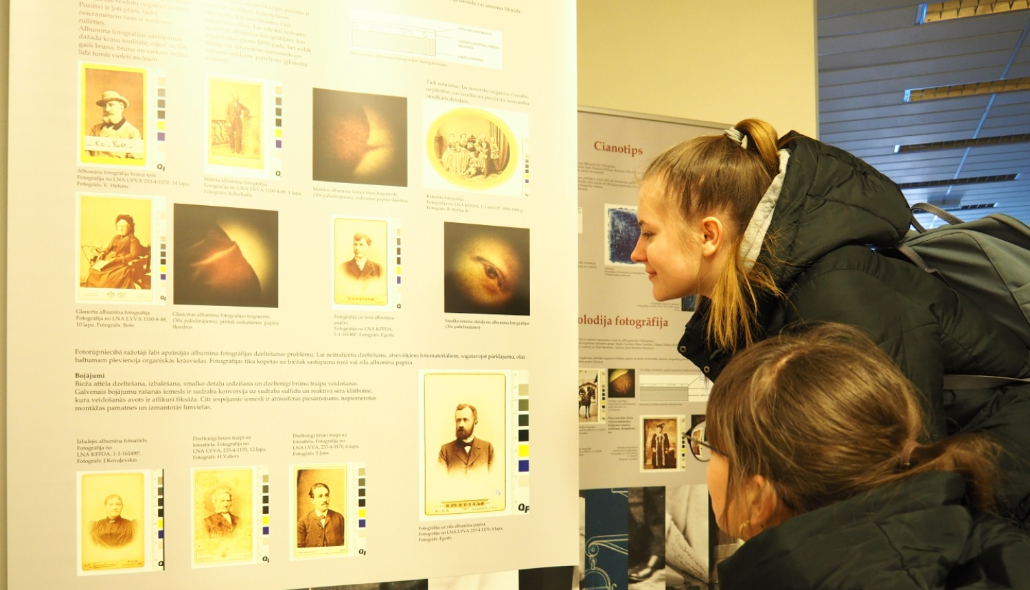 Meites aplūko izstādes plakātu