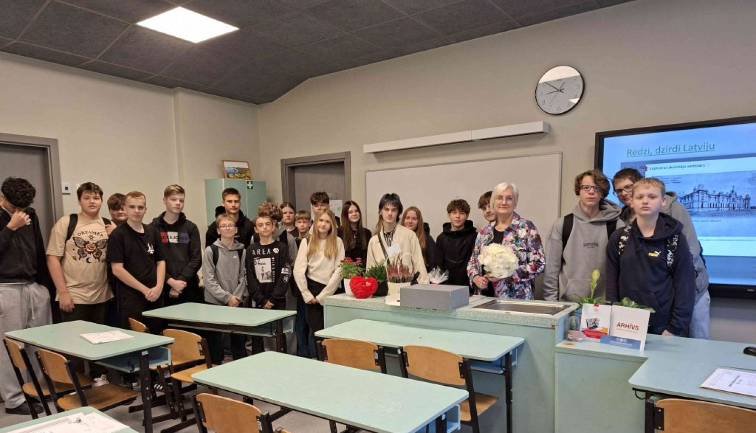 Krāsaina bilde, LNA Valmieras zonālā valsts arhīva eksperte Māra Stabrovska un Valmieras Viestura vidusskolas 8.c klases skolēni