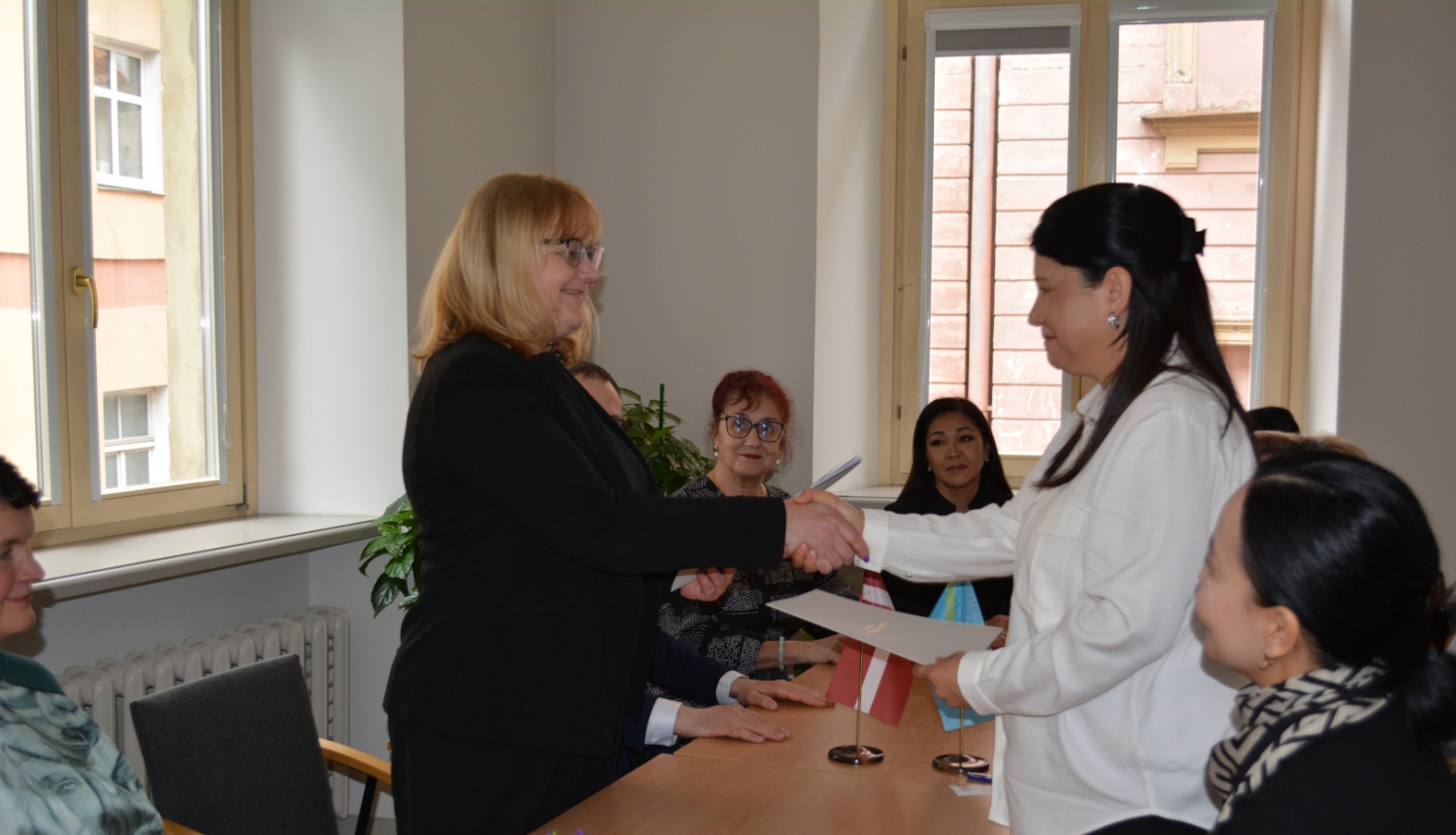 Krāsaina bilde, LNA direktore Māra Sprūdža un Kazahstānas Republikas Kultūras un informācijas ministrijas Arhīvu, dokumentācijas un grāmatu lietu komitejas Centrālā Valsts zinātniski tehniskās dokumentācijas arhīva direktora vietniece Meruerta Baisembajeva paraksta Sadarbības memorandu